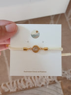 Weißes Kordelarmband mit rundem Anhänger 